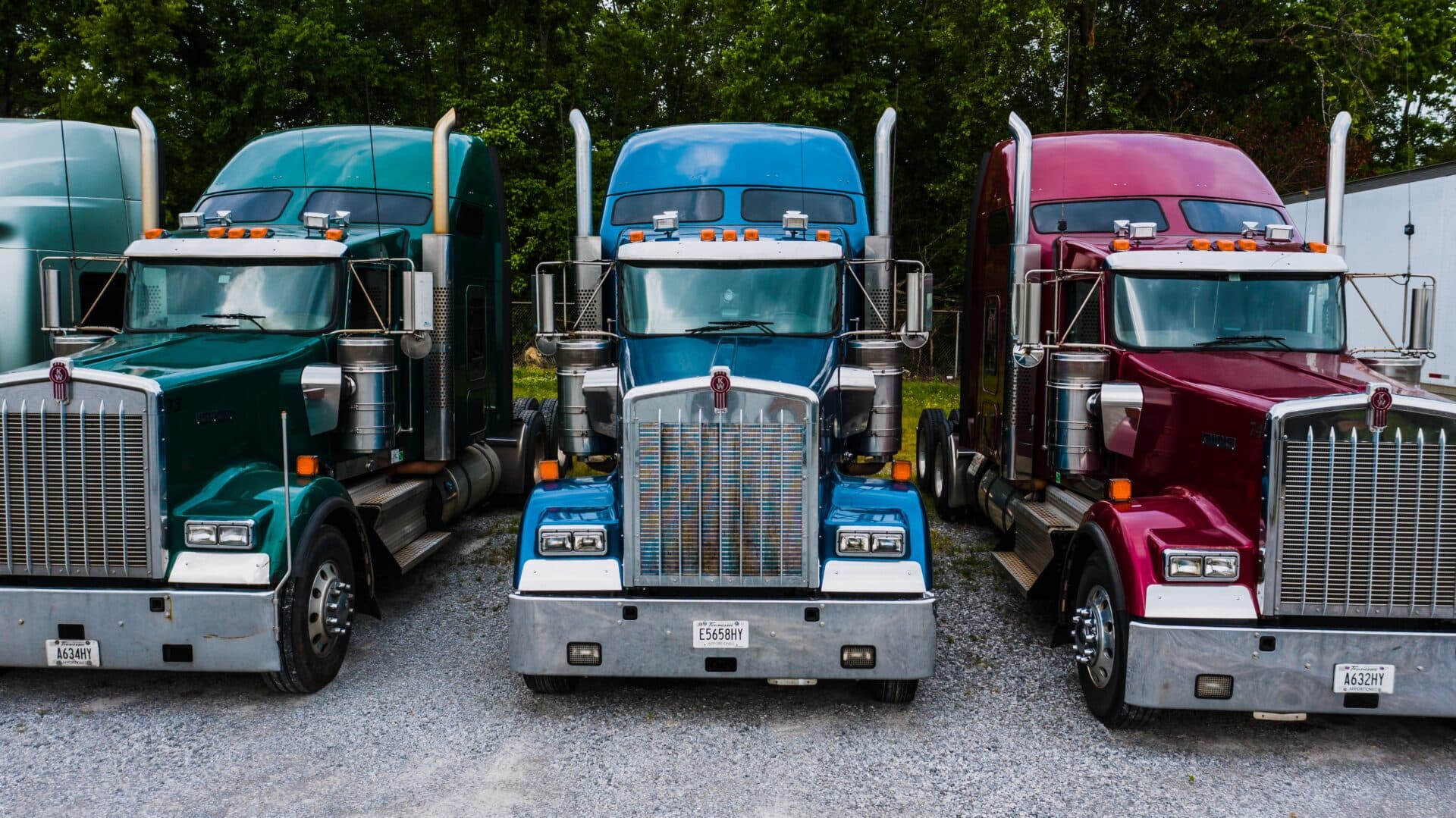Three colorful semi trucks parked side by side